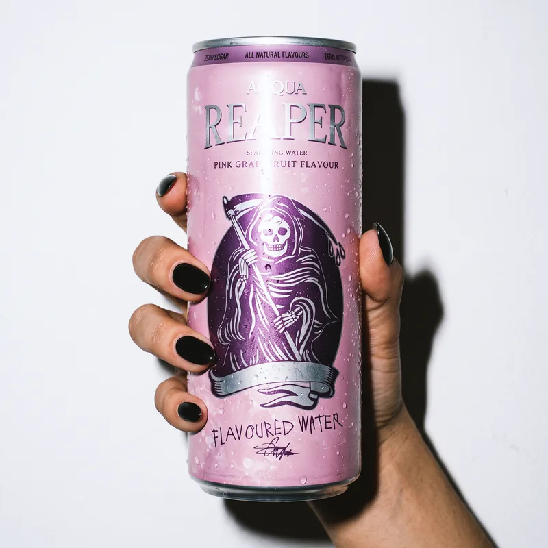 Hand mit schwarzen Nägeln hält eine Dose Pink Grapefruit